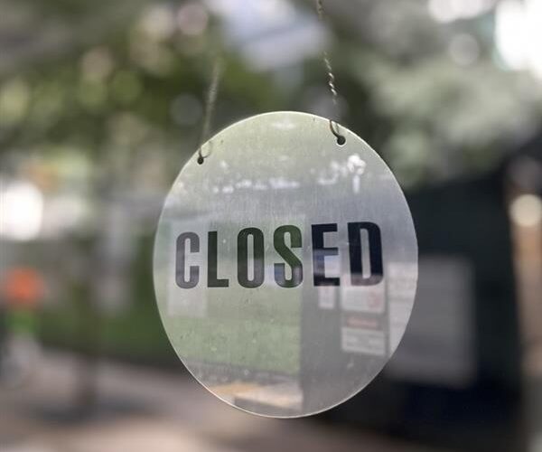 Closed sign hangs in door from a lock out due to breach notice form 7